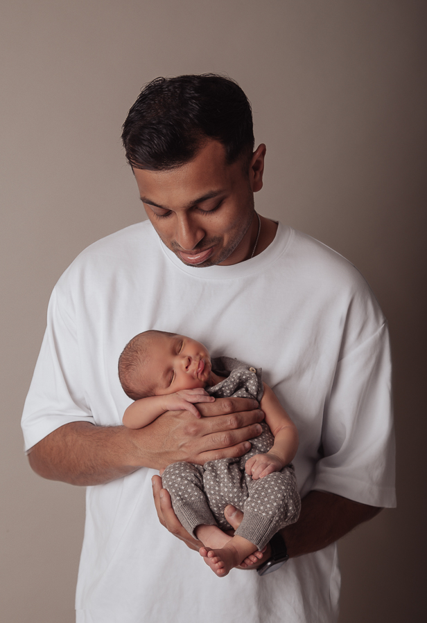 Süße Papa und Babypose für dein Neugeborenenshooting